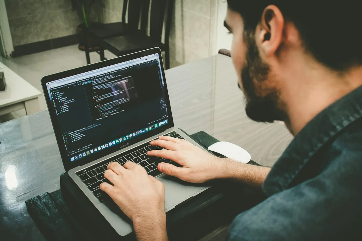 Developer writing code on a laptop at a desk